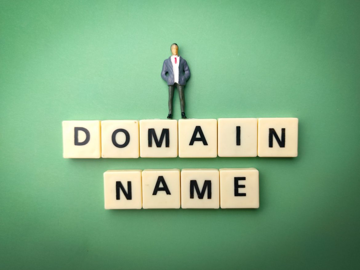 Miniature people and toys word with the word DOMAIN NAME
