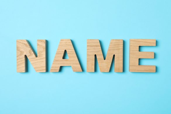 Word Name lined with wooden letters on color background